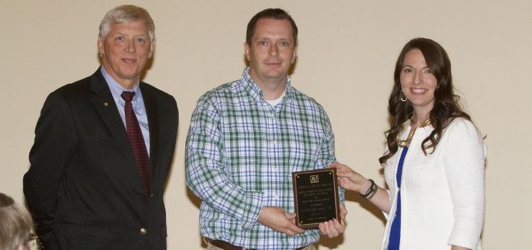 Dr. Glen Borchert, center, assistant professor of biology, accepts the 2013-2014 Semoon and Youngshin Chang Endowed Award for Humanitarian Services from, left, Dr. Julie Estis, president of the USA Faculty Senate, and, right, University President Dr. Tony Waldrop.